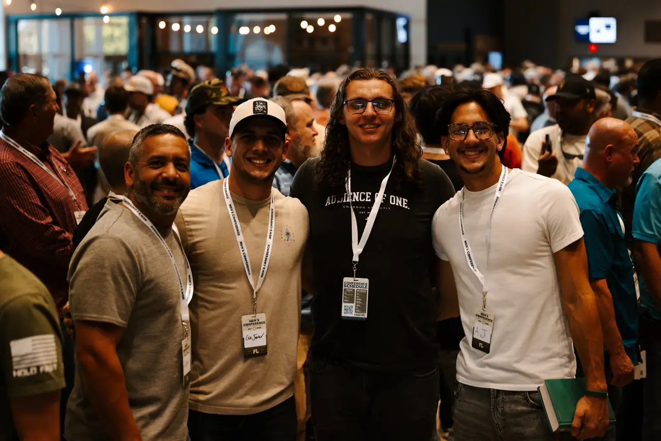 A group of men together in the lobby wearing conference lanyards