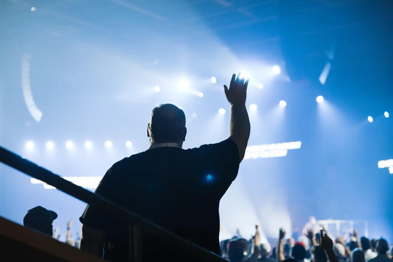 A man with his hand raised during worship